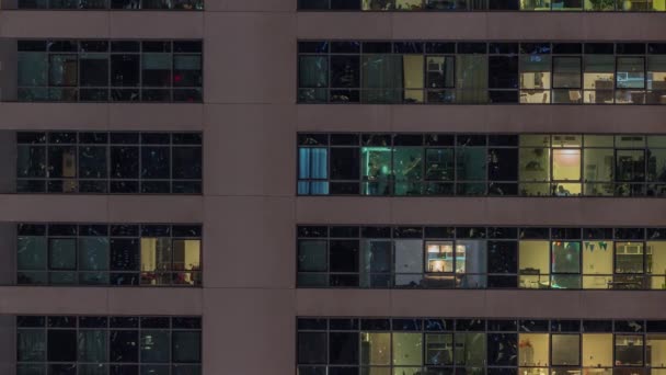 Fenêtres lumineuses dans les immeubles de bureaux et résidentiels modernes timelapse la nuit — Video