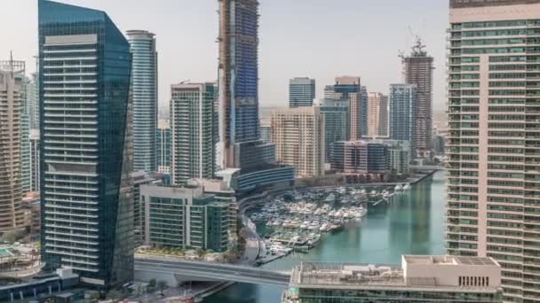 Vista aérea de los rascacielos del puerto deportivo de Dubai alrededor del canal con timelapse de barcos flotantes — Vídeos de Stock