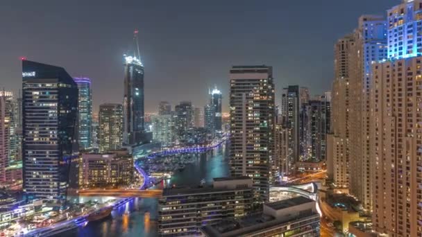 Luchtfoto naar Dubai jachthaven wolkenkrabbers rond kanaal met drijvende boten nacht timelapse — Stockvideo