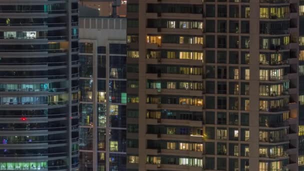 Światła okien w nowoczesnych budynkach biurowych i mieszkalnych timelapse w nocy — Wideo stockowe