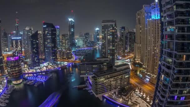 Luchtfoto naar Dubai jachthaven wolkenkrabbers rond kanaal met drijvende boten de hele nacht timelapse — Stockvideo