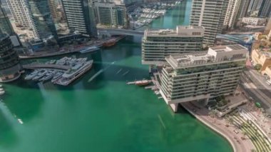 Kanal çevresindeki Dubai marina gökdelenlerine tüm gün yüzen teknelerle hava görüntüsü