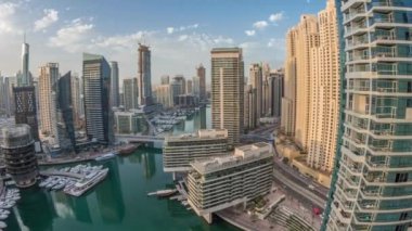 Kanal çevresindeki Dubai marina gökdelenlerine panoramik hava görüntüsü ve yüzen botlar zaman ayarlı
