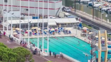 İnsanlar ve Binalar içinde belgili tanımlık geçmiş ile Monaco timelapse deniz yüzme havuzunda.