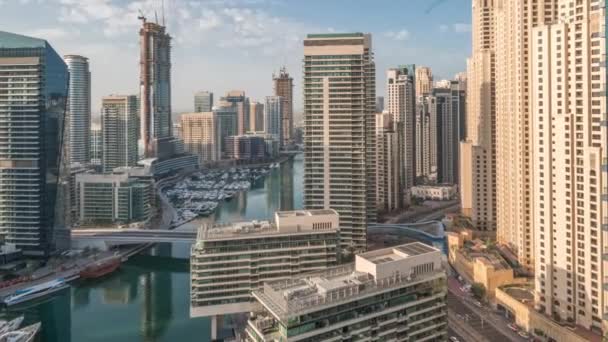 Vista aérea de los rascacielos del puerto deportivo de Dubai alrededor del canal con timelapse de barcos flotantes — Vídeos de Stock