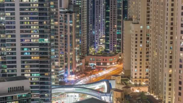 Overzicht van JBR en Dubai Marina skyline met moderne hoogbouw wolkenkrabbers waterkant levende appartementen antenne hele nacht timelapse — Stockvideo