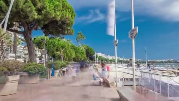 Pessoas andando à beira-mar perto do famoso hiperlapso timelapse La Croisette Boulevard. Riviera Francesa. — Vídeo de Stock