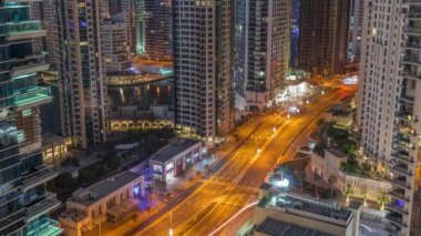 Dubai Marina gökdelenlerindeki hava manzarası ve limandaki en lüks yat gece gündüz saatlerinde, Dubai, Birleşik Arap Emirlikleri