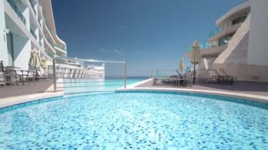 Otel küçük Yüzme Havuzu ile güneşli yansımaları timelapse, Sesimbra, Portekiz