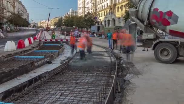 Közúti karbantartási munkák betonozása sok munkással és a keverőgépek időzítésével — Stock videók