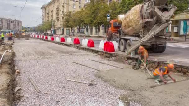 Бетонні роботи для будівництва доріг з багатьма робітниками та машинами змішувача — стокове відео