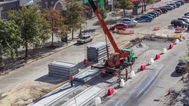 Installation de plaques de béton par grue sur le chantier de construction routière timelapse . — Video