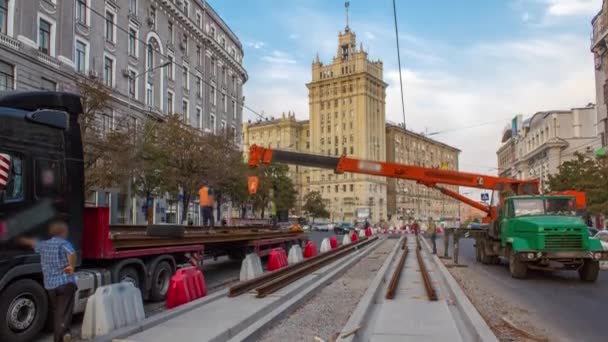 Construcción naranja grúa móvil telescópica descarga rieles de tranvía de timelapse camión . — Vídeo de stock