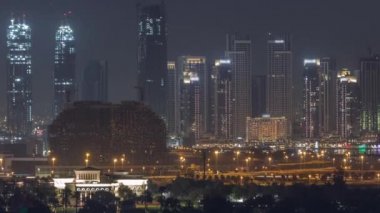 Dubai Creek Limanı 'nda gökdelenleri ve inşaat halindeki kuleleri ile hava gece zaman ayarlı.