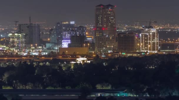 ドバイクリーク近くの建設中のライトアップされた高層ビルや塔空中夜間のタイムラプス. — ストック動画