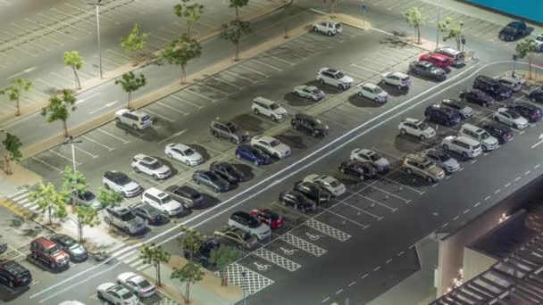 Top View zajęty parking z wieloma samochodami poruszających się w i na zewnątrz nocy timelapse. — Wideo stockowe