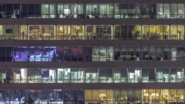 Geceleri ofis binalarının pencereleri, evlerin pencerelerinin ışığı.
