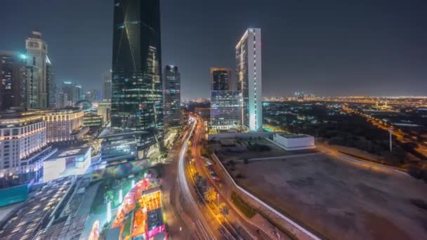 Tráfico por carretera en Dubai International Financial distrito aéreo noche timelapse. Vista panorámica de las torres de oficinas comerciales y financieras. — Vídeos de Stock