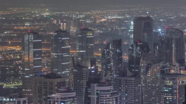 Jumeirah Lakes Towers distrito con muchos rascacielos a lo largo de Sheikh Zayed Road timelapse noche aérea. — Vídeos de Stock