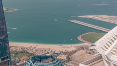 Kalabalık JBR plajında güneş ve denizin tadını çıkaran turistler şemsiyelerin altında oturuyordu.