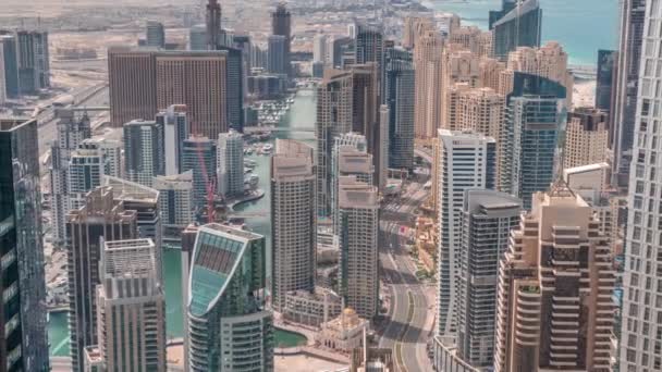 Skyline panoramic view of Dubai Marina showing an artificial canal surrounded by skyscrapers along shoreline all day timelapse. DUBAI, UAE — Stock Video