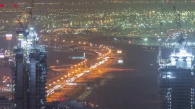 Skyline panoramik manzarası Dubai Marina 'nın aydınlanmış gökdelenleri ve inşaat alanının hava gece zaman çizelgesini gösteriyor. Dubai, BAE