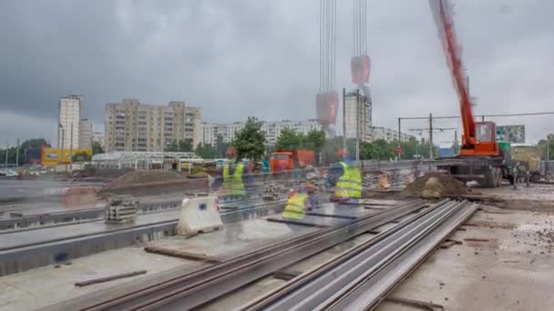 Pomarańczowa konstrukcja żurawia teleskopowego rozładowywanie szyn tramwajowych z timelapse ciężarówki. — Wideo stockowe