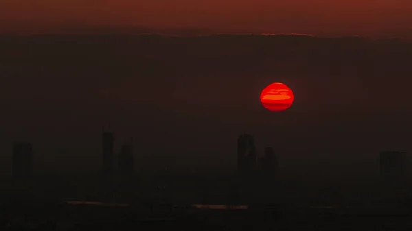 緑の上に日の出とドバイマリーナからのアルバーシャの高さ地区の航空時間経過 上からゴルフ場近くのタワーや高層ビルの後ろに昇る太陽 — ストック写真