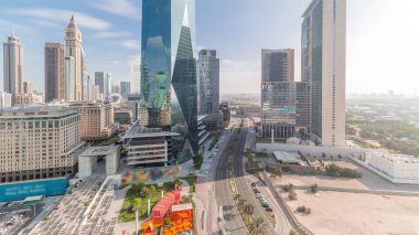 Tüm gün boyunca Dubai Uluslararası Finans Bölgesi hava zaman çizelgesi. İş ve finans kulelerinin panoramik manzarası. Şehir merkezine yakın otelleri olan gökdelenler ve hızlı hareket eden gölgeler.