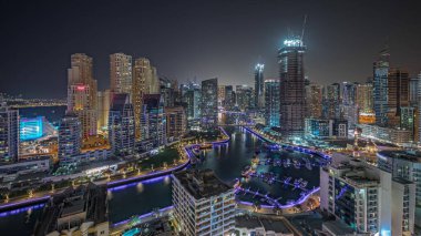 Panorama, Dubai Marina 'yı limana park etmiş birkaç tekne ve yatla gösteriyor. Kanal havası çevresindeki gökdelenleri aydınlatıyor. Arka planda JBR bölgesi kuleleri