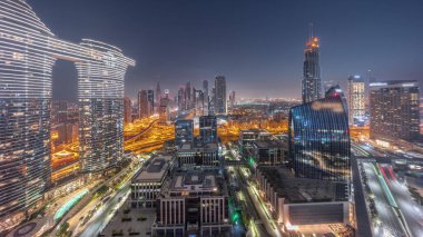 Fütürist Dubai Şehir Merkezi ve finans bölgesi gökyüzü gece gündüz geçiş zamanı. Gün doğmadan önce caddelerde trafik olan birçok kule ve gökdelen