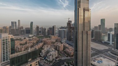 Gün batımında büyük, fütüristik bir şehrin göksel panoramik ufuk çizgisini gösteren panorama. Gökdelenleri ve geleneksel evleri olan iş sahası ve şehir merkezi bölgesi, Dubai, Birleşik Arap Emirlikleri