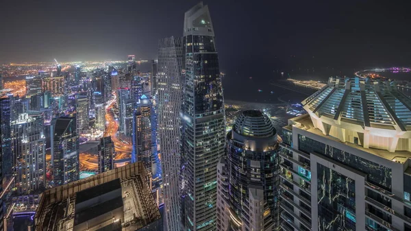 全景显示Jbr区和迪拜码头与Jlt 摩天大楼之间的高速公路上的交通夜间飞驰而过 照明现代化塔和建筑工地 — 图库照片