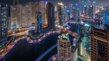 Dubai Marina hava sahasının en uzun bloğundaki çeşitli gökdelenlerin görüntüsü suni kanallı gece zaman ayarlı. Pencereleri ve yatları yanıp sönen bir sürü kule var.