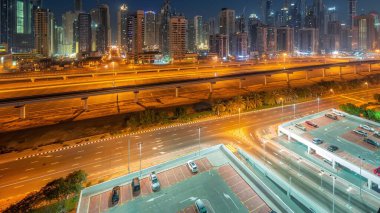 Dubai marinası gece gündüz gökdelenlerin en yüksek bloğu gün doğumundan önce geçiş zamanı. JLT bölgesinden apartman binalarına, otellere ve otoyol yakınlarındaki iş kulelerine hava manzarası.