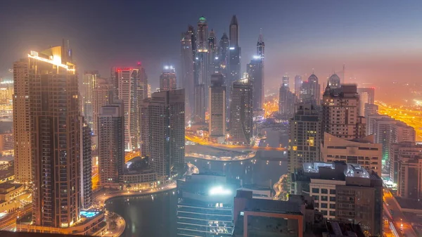 通过人工运河 可以看到迪拜码头最高交点区的各种摩天大楼从夜到日的过渡时间 日出前许多塔楼和游艇雾蒙蒙的早晨 — 图库照片