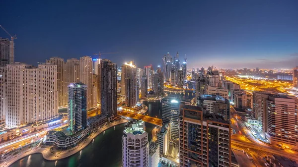迪拜港湾航行楼最高交接处的各种摩天大楼全景 经过人工运河的昼夜过渡时间 Jbr区的许多塔楼和游艇在日出前 — 图库照片