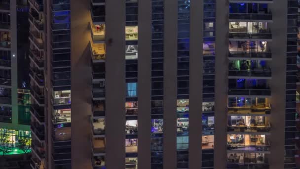 Luz en ventanas de torres modernas. Exterior del edificio de apartamentos por la noche con ventanas brillantes timelapse. — Vídeo de stock