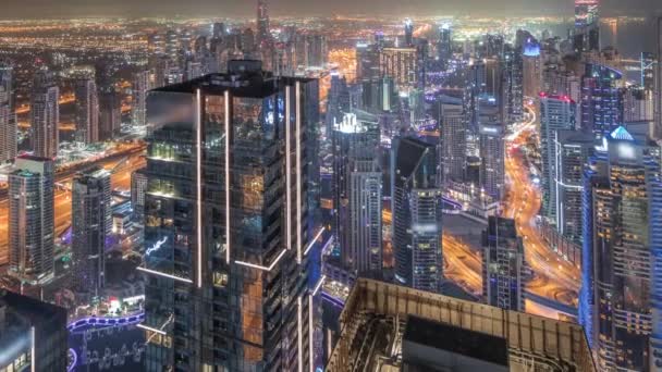 Dubai Marina e JLT distrito com tráfego na estrada entre arranha-céus aéreos durante toda a noite timelapse. — Vídeo de Stock