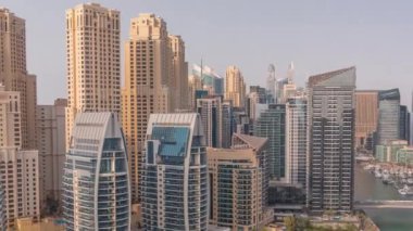 Dubai Marina 'da limana park etmiş çok sayıda tekne ve yat ve kanalın etrafında gökdelenler var..