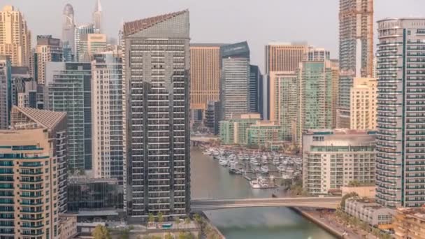 Dubai Marina с несколькими лодками и яхтами, припаркованными в гавани и небоскребами вокруг канала. — стоковое видео