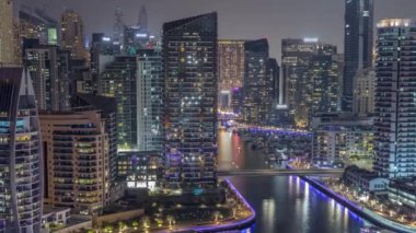 Dubai Marina 'da limana park etmiş birkaç tekne ve yatları ve kanalın etrafında gökdelenleri var..