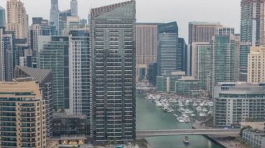 Dubai Marina 'da limana park etmiş birkaç tekne ve yatları ve kanalın etrafındaki gökdelenleri..