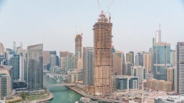 Dubai Marina 'da limana park etmiş çok sayıda tekne ve yat ve kanalın etrafında gökdelenler var..