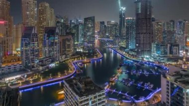 Dubai Marina 'da limana park etmiş birkaç tekne ve yatları ve kanalın etrafında gökdelenleri var..