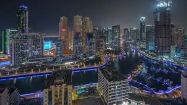 Dubai Marina 'da limana park etmiş birkaç tekne ve yatları ve kanalın etrafında gökdelenleri var..