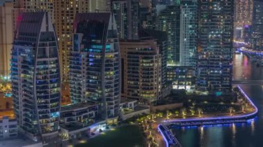 Dubai Marina 'da limana park etmiş birkaç tekne ve yatları ve kanalın etrafında gökdelenleri var..