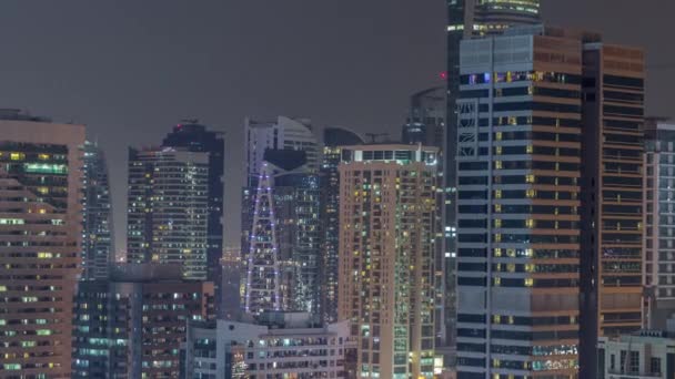 Сучасні хмарочоси в Дубаї Марина, близько до багатьох освітлених вікон з повітряним нічним таймелапсисом.. — стокове відео