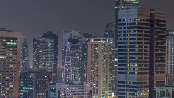 Rascacielos modernos en Dubai Marina, vista de cerca a muchas ventanas iluminadas timelapse noche aérea. — Vídeo de stock