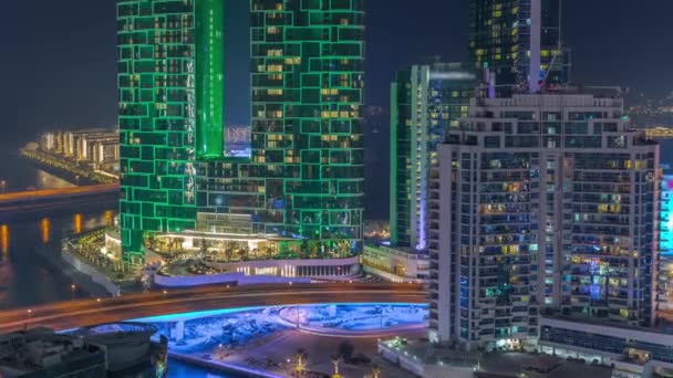 Paseo marítimo y paisaje urbano de Dubái visto desde Dubai puerto deportivo noche timelapse. Vista aérea al distrito JBR y a la isla Bluewater detrás — Vídeo de stock